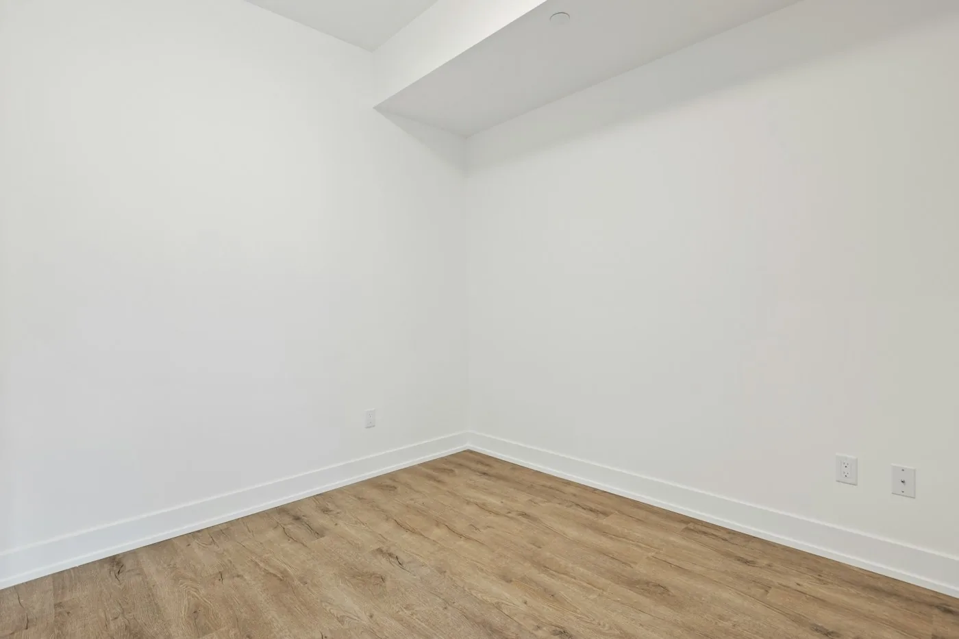 Bare room with parquet flooring and white walls