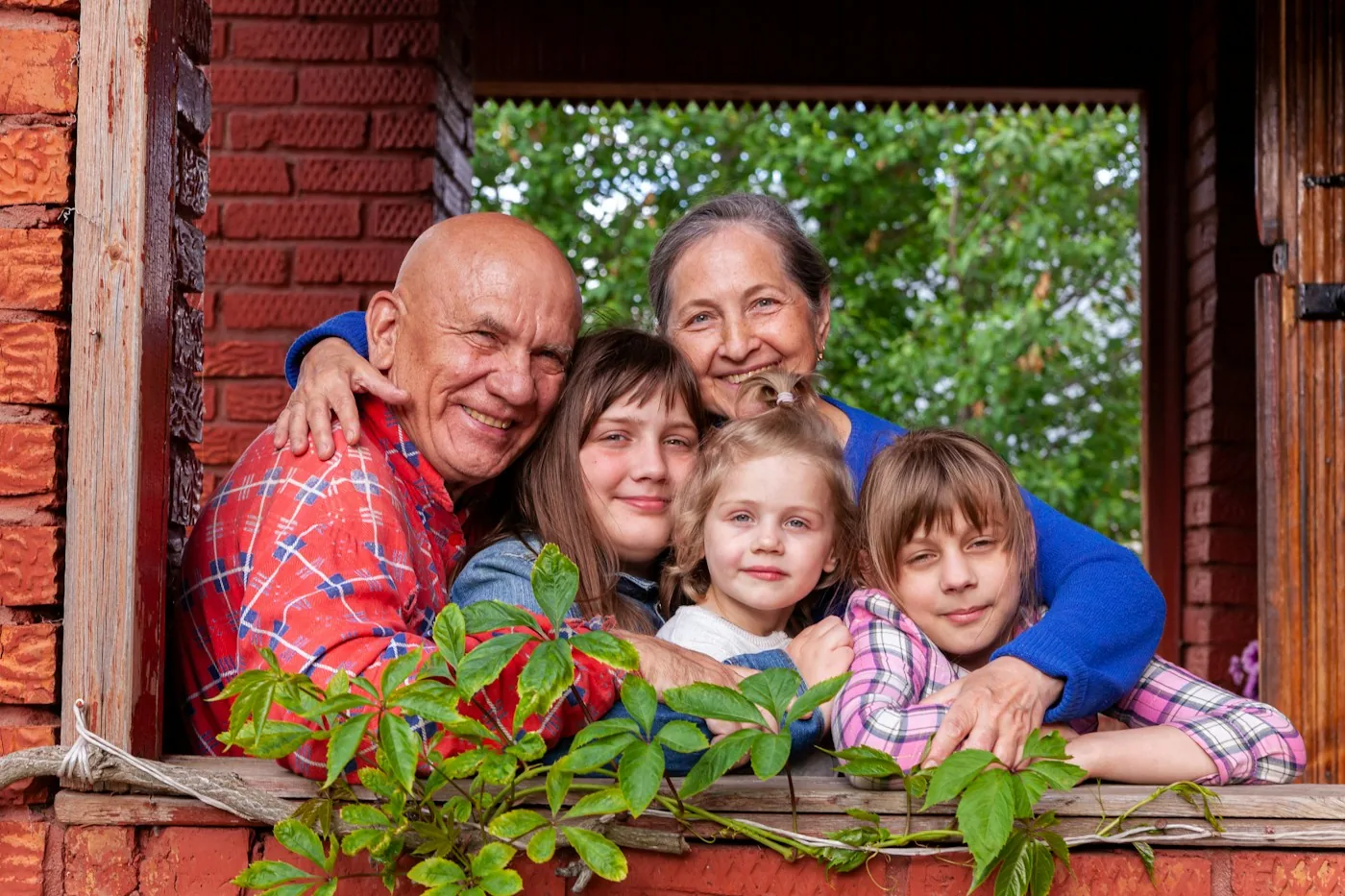 Multigenerational family together at a brick-framed home doorway