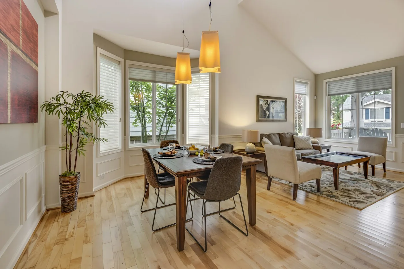 Wood dining table beneath pendant lights in a furnished home