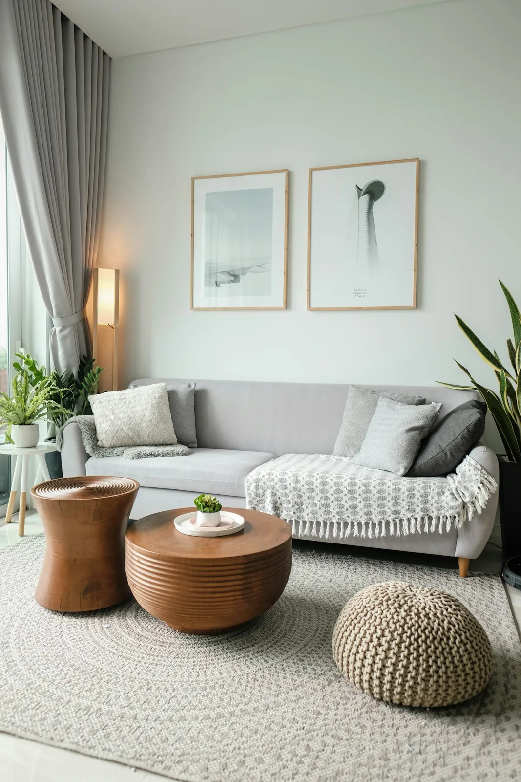 Gray sofa with cushions beside leafy houseplants